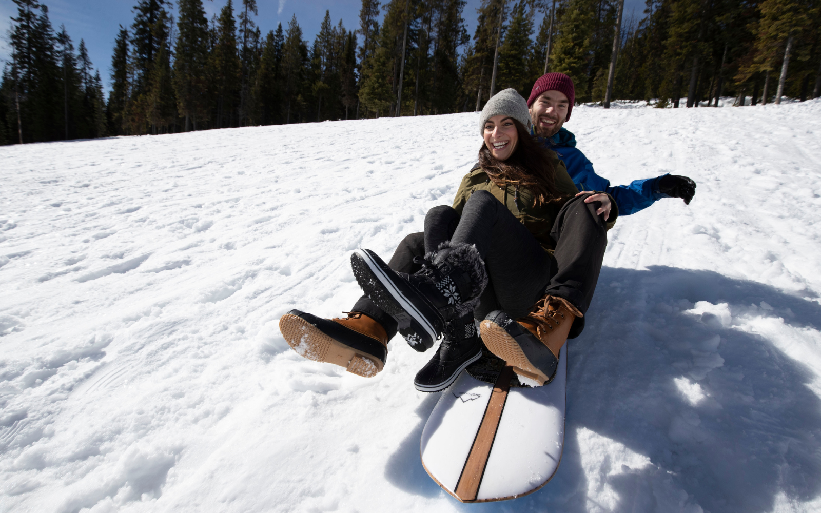 womens snow boots featured in a photo of woman sledding down a snowy hill