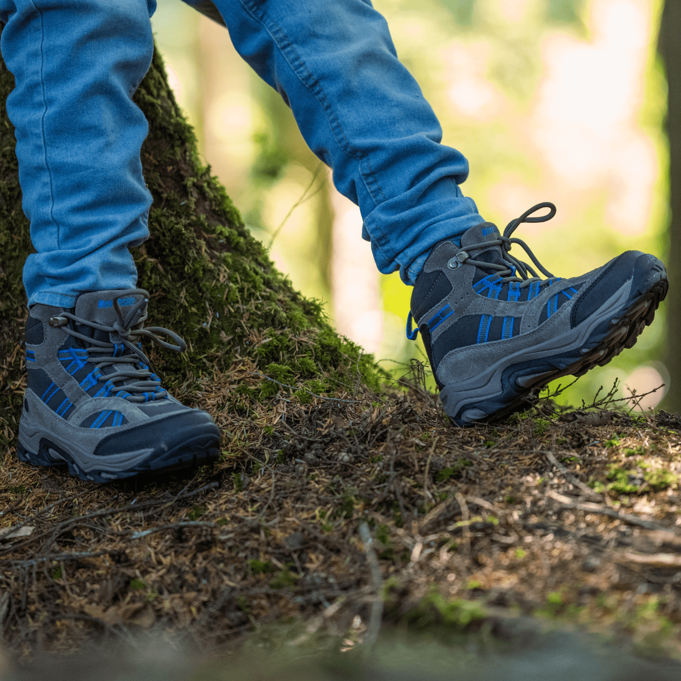 kid leaning on tree showing off his waterproof hiking boots for kids
